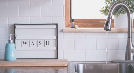 faucet with water and soap in bathroom with wash inscription