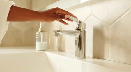 person holding stainless steel faucet